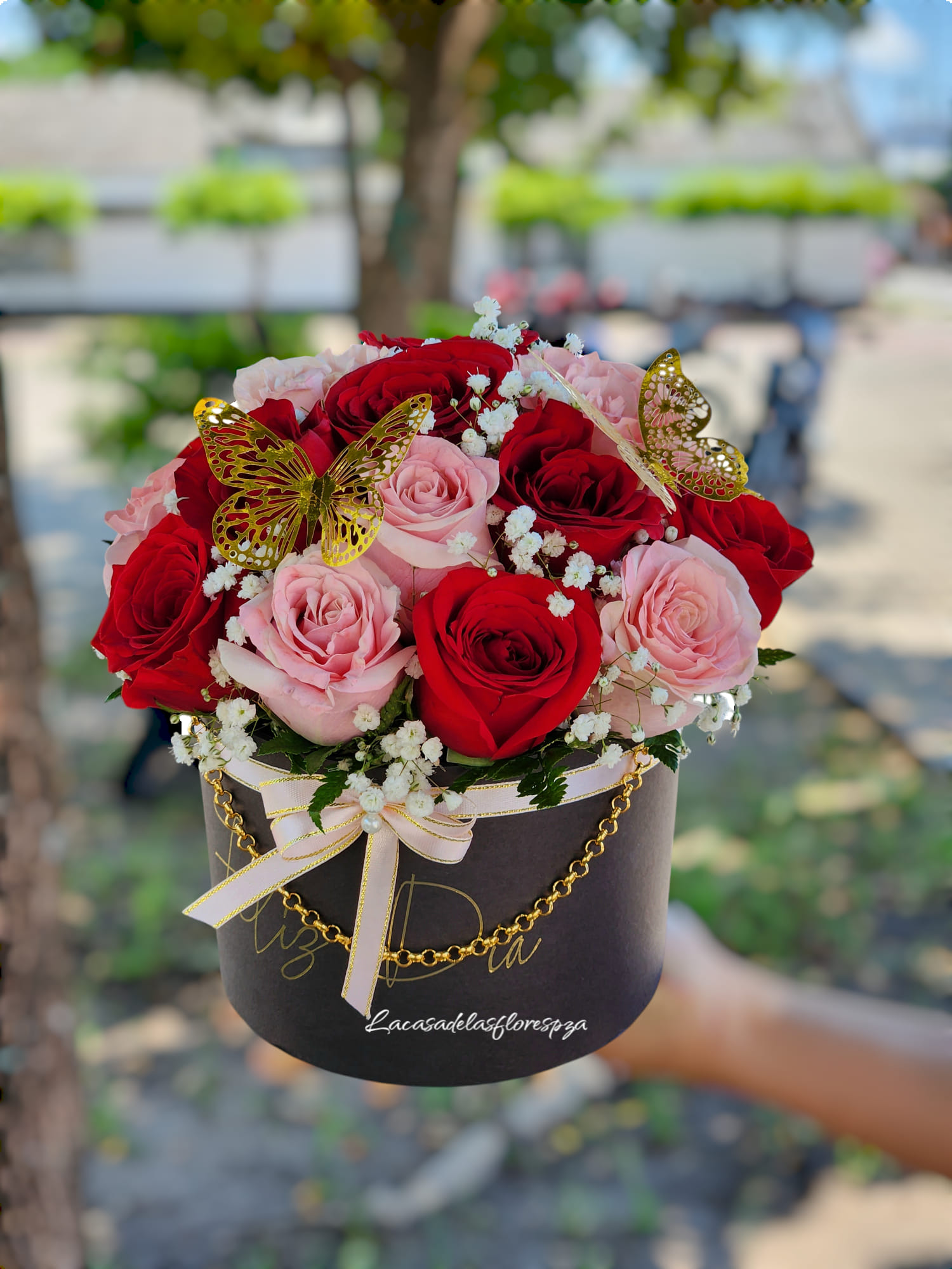 Hat box elegante con rosas rojas y rosadas con mariposas doradas